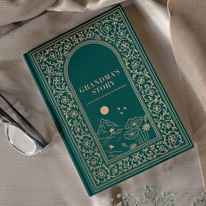 Decorative book titled 'Grandma's Story' on a textured surface with flowers and scissors. Guided memory journal book for grandmothers.