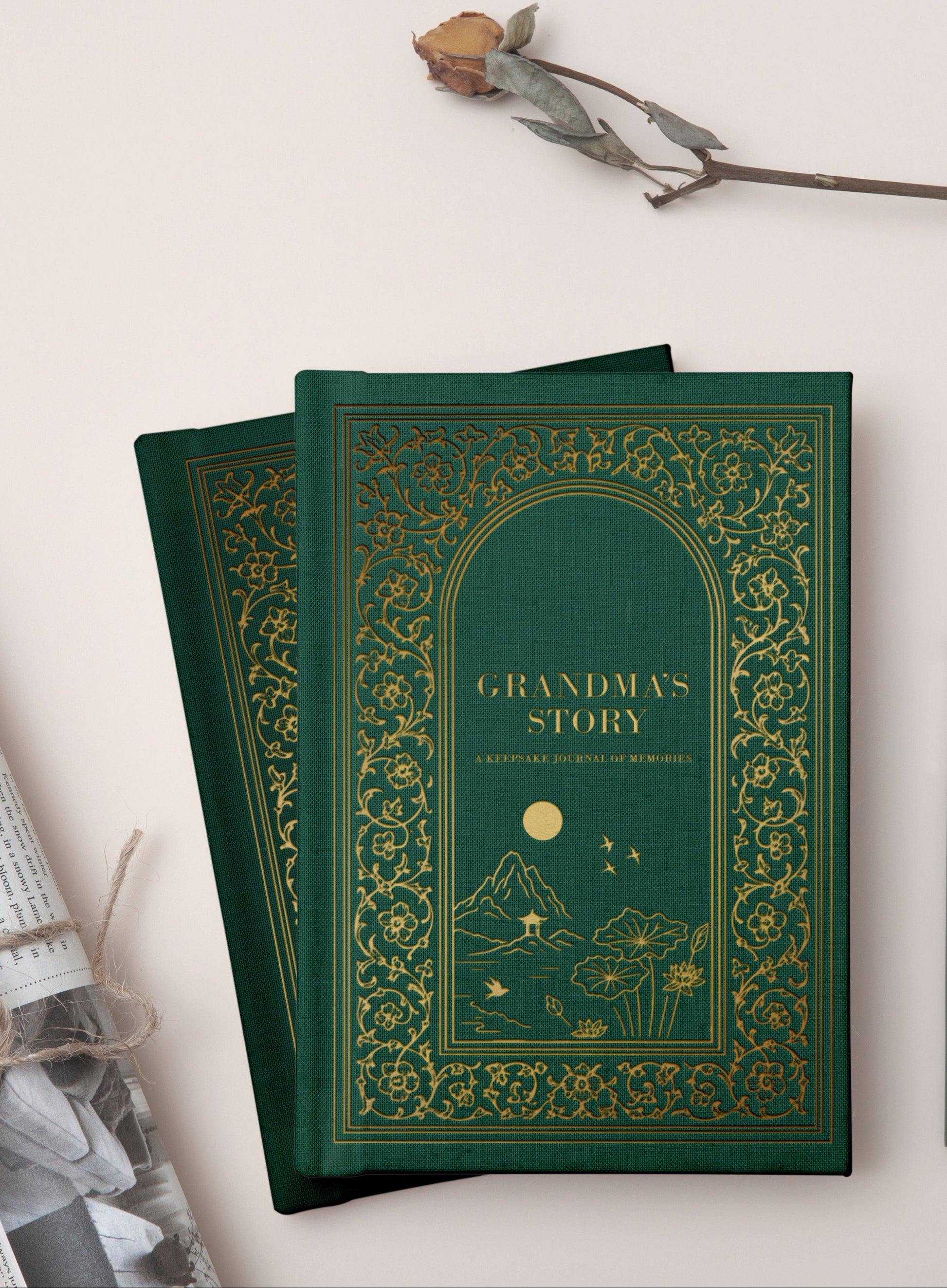 Green book titled 'Grandma's Story' with a pen and rolled paper on a light background
