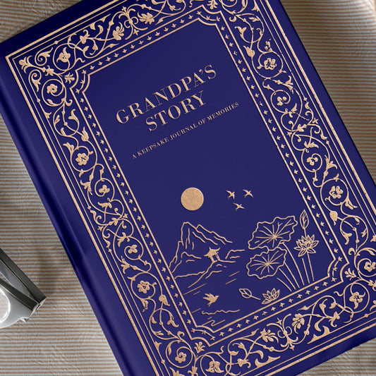 Blue book titled 'Grandpa's Story' on a beige fabric background with flowers.